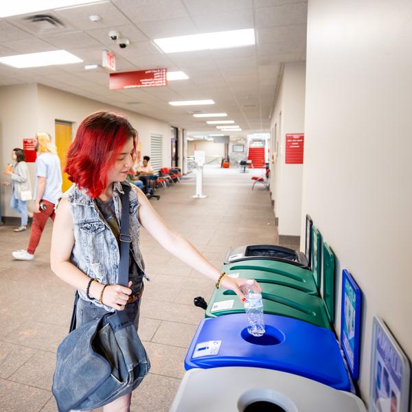 Student recycling a plastic bottle